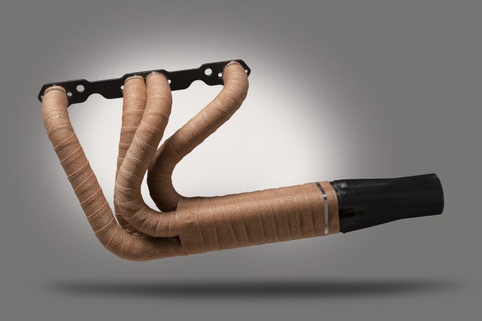 Copper-colored exhaust header wrap with a textured surface, designed to insulate and reduce heat. The wrap is shown on a set of exhaust headers, highlighting its flexibility and fit for automotive applications.