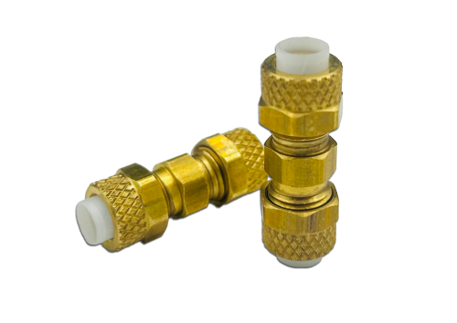 Two brass union fittings with textured grip surfaces and white inner components are shown. One fitting is upright, while the other is lying on its side.