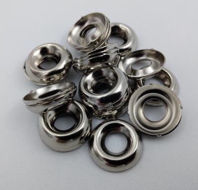 A pile of shiny metal 601 Finishing Washers with an 82° angle, arranged on a plain surface.