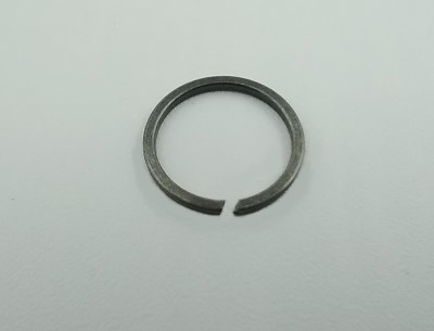 A stainless steel snap ring with an open end, lying flat on a plain light-colored surface.