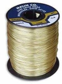 A spool of brass safety wire, featuring tightly wound, shiny brass strands. The top label displays product details. The wire is used for securing fasteners and other applications requiring durable, corrosion-resistant material.