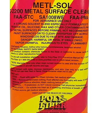A brightly colored spray bottle labeled "METL-SOL 2200 METAL SURFACE CLEANER" with cautionary information about its use, safety warnings, and handling instructions. The background features a vibrant design in yellow, orange, and red.