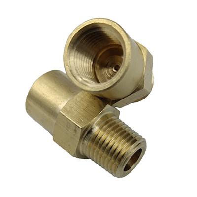 Two brass restrictor fittings, one lying on its side showing the threaded interior, and the other upright displaying the threaded exterior.