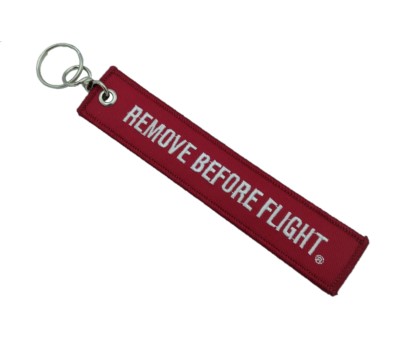 Red aviation keychain with the text "REMOVE BEFORE FLIGHT" in white.