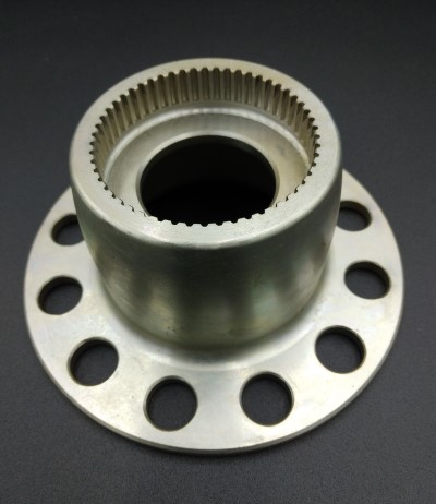 Metal propellor mount with a cylindrical center and a circular base featuring multiple evenly spaced holes, set against a dark background.