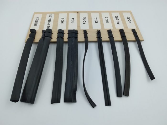 A display board featuring various types of rubber channels, each labeled with a code. The channels vary in width and design, showcasing different styles and applications.