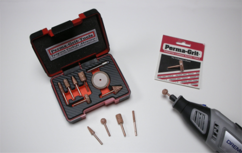 A rotary tool set with various attachments is displayed. The set includes a case with bits and a separate rotary tool. Packaging labeled "Perma-Grit" is visible in the background.