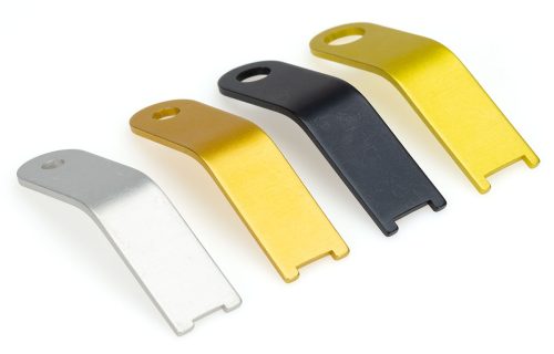 Image of a Shop Head Rivet Gauge Set featuring four metal gauges in silver, gold, black, and yellow. Each gauge has a hole at one end and a notched tip at the other, used for measuring rivet head sizes.