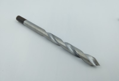 A silver drill bit designed for plastics, featuring a spiral groove and a pointed tip, is placed on a plain white background.