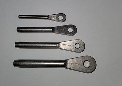 Four metal eye ends of varying sizes are arranged in a row on a plain background. Each eye end features a cylindrical shaft and a flat, rounded end with a circular hole.