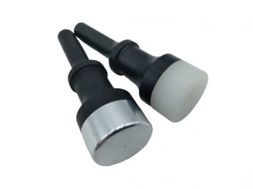 Two peening tools with black handles and round striking surfaces, one metallic and the other white, are shown side by side on a white background.