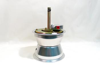 A metallic, cylindrical device with a central vertical rod and a small red component on top, set against a plain white background.