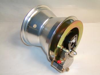 A metallic wheel hub with a brake assembly attached, featuring a shiny silver finish and a circular design. The brake mechanism is mounted on one side, with visible bolts and a small red component.