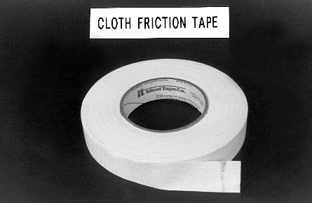 A roll of cloth friction tape with a small section peeled off, set against a dark background. A label above reads "Cloth Friction Tape."