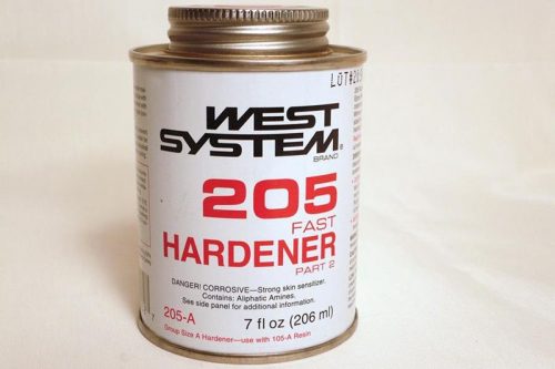 A metal can of West System 205 Fast Hardener, containing 7 fl oz (206 ml). The label includes product details and usage instructions. The can has a screw-on lid and is placed on a white surface.
