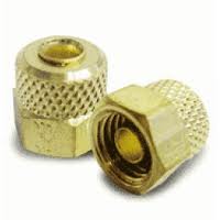 Two brass knurled nuts, one upright and one on its side, showing threaded interiors.