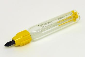 A transparent, cylindrical voltage tester with a yellow cap and black tip, resting on a white surface. The body has measurement markings.