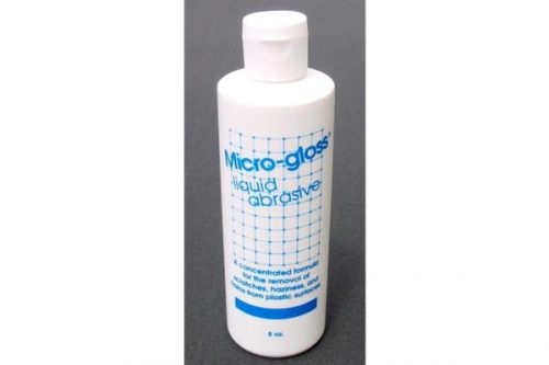 White bottle of Micro-gloss liquid abrasive with blue text, featuring a grid design. The bottle has a white cap and is set against a dark background.
