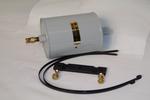 A gray cylindrical electrical component with a metal connector is placed next to a black cable with brass fittings on a white background.
