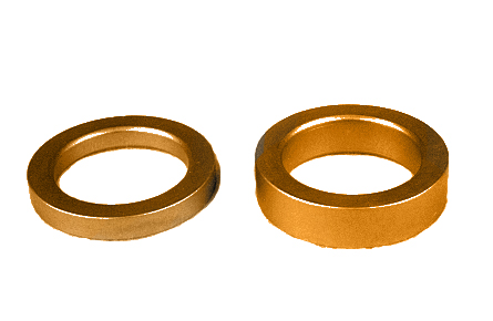 Two bronze-colored metal rings are placed side by side on a white background. The ring on the left is thinner, while the one on the right is thicker.