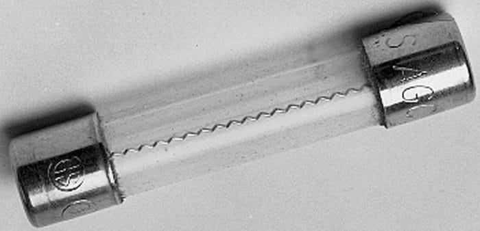 A cylindrical glass fuse with metal caps on both ends, featuring a visible thin wire inside.