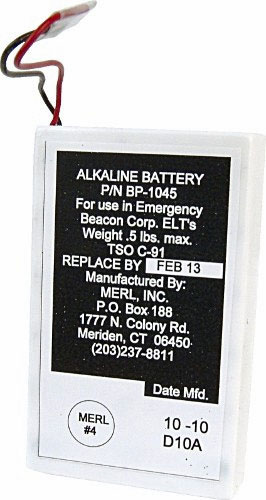 Rectangular alkaline battery with label showing part number BP-1045, for emergency beacons. Replace by February 13. Manufactured by MERL Inc., Meriden, CT. Weight: 0.5 lbs. Date code: 10-10 D10A.