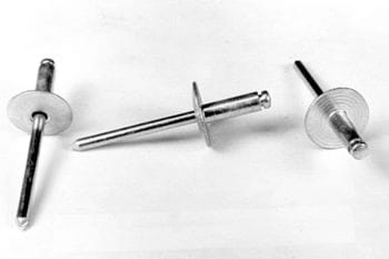 Three metal rivets with flat heads and long stems are positioned on a white surface.