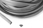 A coiled rubber hose with a cut section showing its cross-section shape. The hose is gray and lies on a white surface.