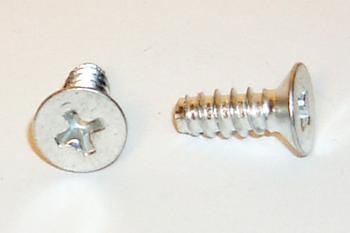 Two silver Phillips head screws on a white surface, one upright and the other lying on its side, showing the threaded body and flat head.