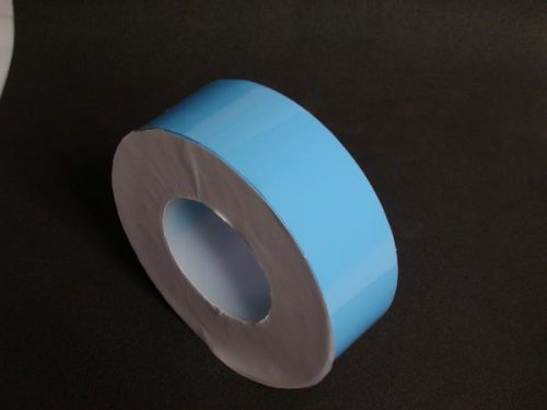 A roll of light blue adhesive tape with a white inner core, positioned on a dark surface.