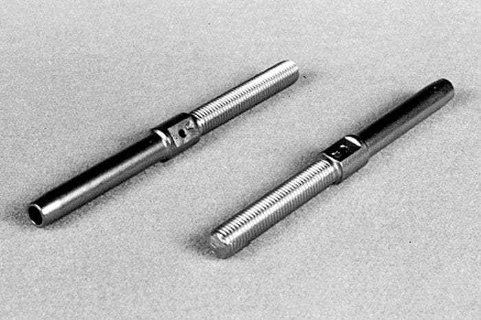 Two metal rods with threaded ends placed on a flat surface.