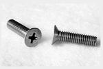 Two metal screws on a white surface, one standing upright and the other lying on its side, both with Phillips heads.