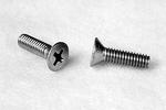 Two metal screws on a light surface, one standing upright and the other lying flat, both with Phillips heads.