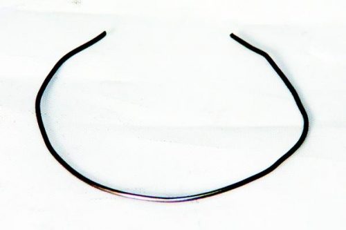 A thin, black metal headband with a simple, open-ended design lies on a white surface.