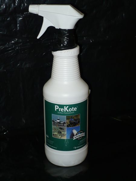 White spray bottle labeled "PreKote" with images of aircraft and a person cleaning, set against a dark background.