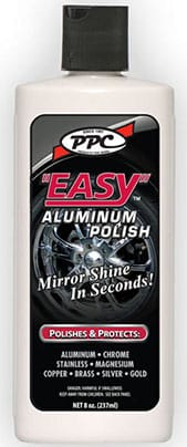 White bottle of PPC Easy Aluminum Polish with black label. Text reads "Mirror Shine In Seconds! Polishes & Protects: Aluminum, Chrome, Stainless, Magnesium, Copper, Brass, Silver, Gold." Image of a polished wheel in the background.