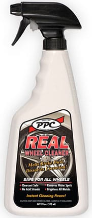 A spray bottle labeled "PPC Real Wheel Cleaner" with black and red text. The label mentions it is safe for all wheels and provides instant cleaning power. The bottle is beige with a black trigger nozzle.