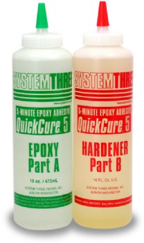 Two bottles of System Three QuickCure 5 epoxy adhesive, labeled Part A and Part B. Part A has a green cap, and Part B has a red cap. Each bottle contains 16 fluid ounces.