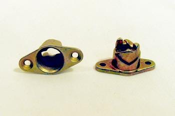 Two metal wall anchors are shown on a light surface. One anchor is cylindrical with two mounting holes, and the other is a split-type anchor with a similar base. Both are designed for securing objects to walls.