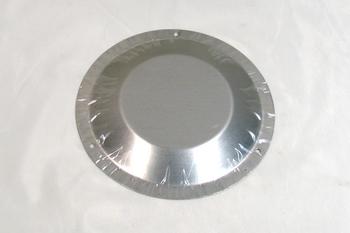 A round metal pie pan with a shiny surface, covered in clear plastic wrap, placed on a white background.