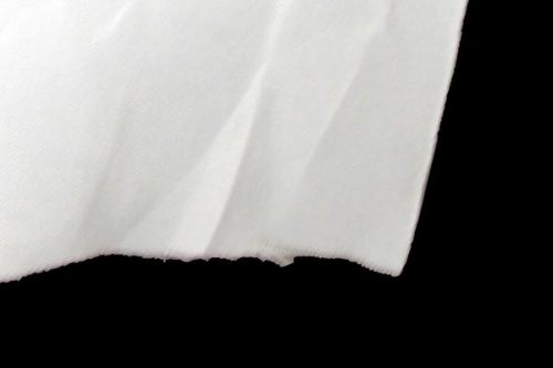 Close-up of a crumpled white sheet of paper against a black background.