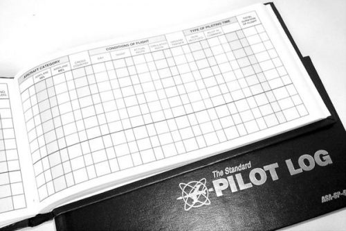 Open pilot logbook showing a grid layout for recording flight details. The cover reads "The Standard Pilot Log."