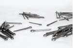 A metal cotter pin with a looped head and split ends lies on a white surface.