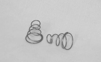 Two metal springs on a plain surface, one coiled tightly and standing upright, the other lying horizontally and more loosely coiled.