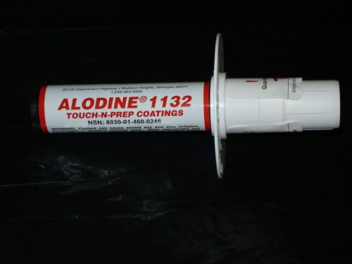 A white cylindrical applicator labeled "ALODINE 1132 TOUCH-N-PREP COATINGS" with red text, featuring a white cap and flange, is placed against a dark background.