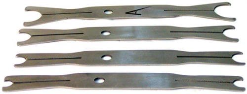 Four metal tension test specimens with hourglass shapes, each featuring a central hole and black markings, are aligned horizontally.