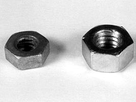 Two hexagonal nuts of different sizes on a plain surface, with the smaller nut on the left and the larger nut on the right.