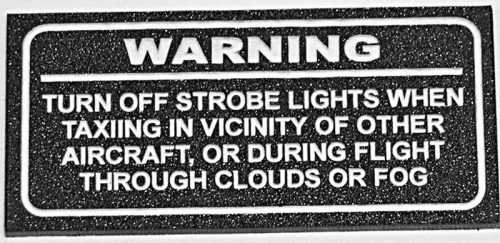 Warning sign instructing to turn off strobe lights when taxiing near other aircraft or flying through clouds or fog.