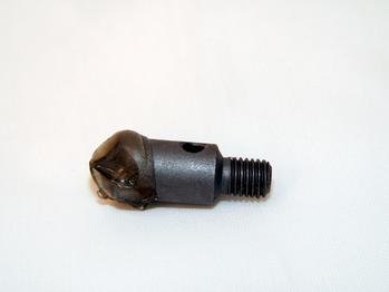 A metal threaded bolt with a rounded, worn tip and a smooth cylindrical body, lying on a plain white surface.
